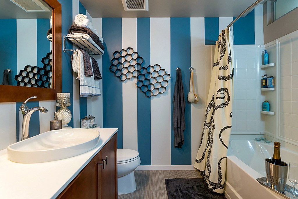 a bathroom with blue and white striped walls and a sink and toilet a bathroom with blue and white striped walls and a sink and toilet at Ann Arbor City Club, Michigan, 48104